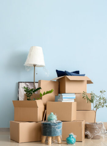 Cardboard boxes with belongings in new flat on moving day