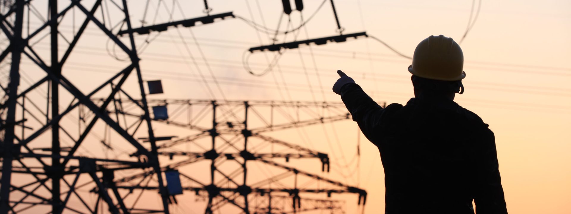 In the evening, electricity workers and pylon silhouette, Power workers at work